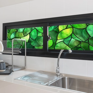 Close-up of artistic green leaf stained glass window film on a kitchen sliding window