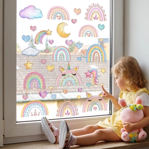 Close-up of a child touching colorful rainbow and unicorn static cling window stickers