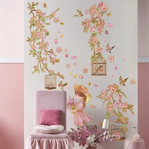 Detail of pink floral wall decals with gold birdcages and a cartoon girl on a grey wall