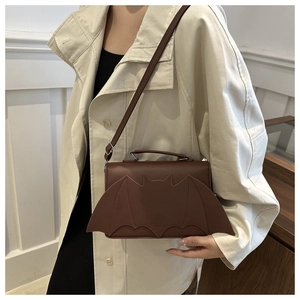 Detail of bat wing shaped flap on dark brown leather crossbody bag for women