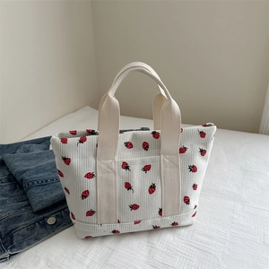 Minimalist corduroy tote bag featuring red strawberry prints and white canvas handles