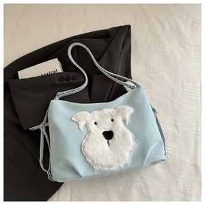 Detail view of light blue tote bag featuring a white plush puppy head with cute embroidery