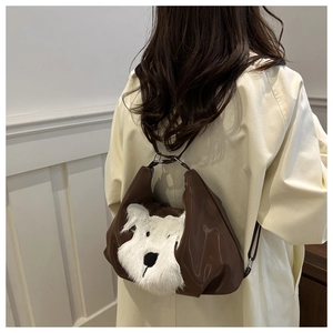 Detail of creative plush dog pattern on dark brown patent leather tote shoulder bag