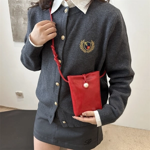 Petit sac bandoulière rouge pour téléphone avec perle décorative porté par un mannequin
