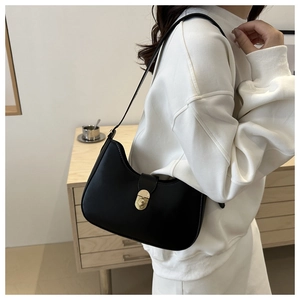Detail of black leather crescent underarm bag with gold metal twist lock and shoulder strap