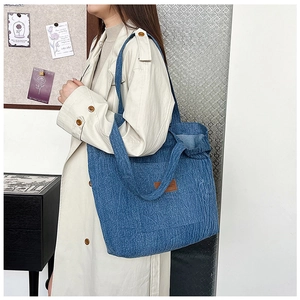 Blue denim canvas tote bag styled as a crossbody bag for casual daily outfit
