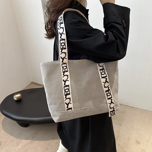 Minimalistische graue Cord-Einkaufstasche mit bedrucktem Gurt an einem Model