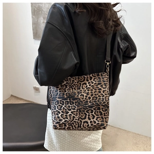 Detail of leopard print canvas bucket bag showing gold hardware and adjustable strap