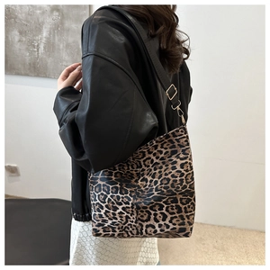 Leopard print canvas bucket bag with adjustable black shoulder strap and gold hardware