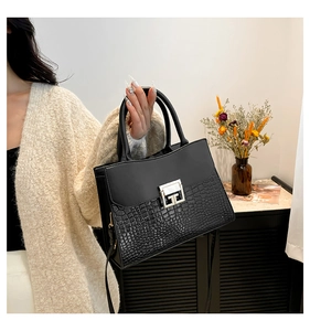 Dettaglio dell'elegante borsa nera a motivo coccodrillo con fibbia in metallo argento