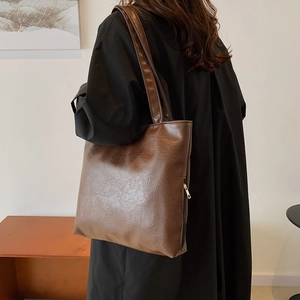 Minimalist large brown faux leather tote bag with vintage pleated texture and zipper detail
