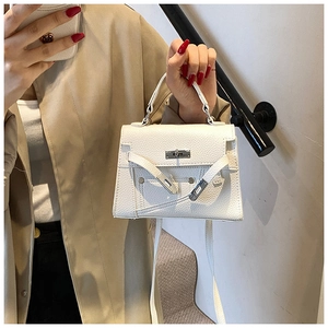 Detailed macro shot of white lychee textured leather and metallic twist lock on handbag