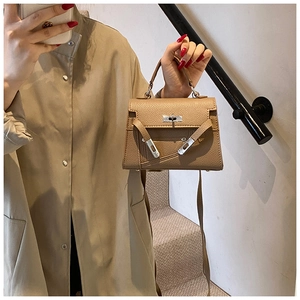 Detail of khaki pebbled leather mini handbag with silver hardware and detachable strap