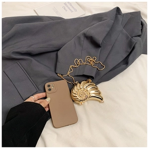 Detailed view of luxury gold seashell evening bag with metallic texture and chain