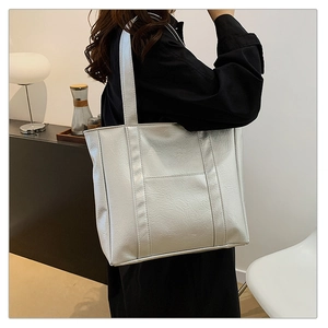 Silver metallic tote bag showing detailed pleated leather texture and side pocket design