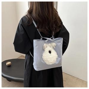 Détail du sac cabas bleu clair avec patch chien en peluche porté à l'épaule