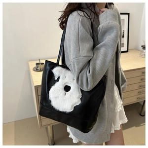 Détail d'un sac cabas noir avec motif chien en peluche blanc dans une scène de vie moderne