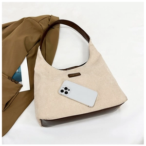 Detail view of corduroy tote interior showing smartphone storage and leather trim