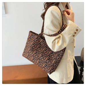 Close-up of leopard print tote bag on shoulder over corduroy jacket for autumn style