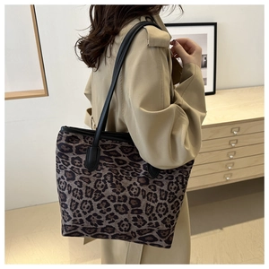 Detailed view of large leopard print tote bag worn with a beige trench coat