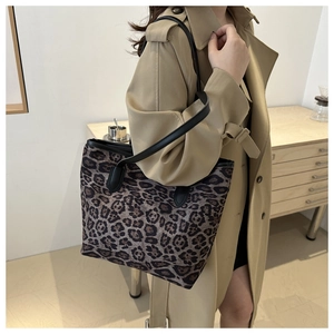 Dettaglio borsa shopper leopardata con spalline in pelle su modella in trench kaki