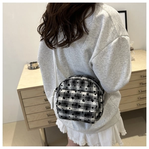 Detailed back view of a mini black and white heart pattern shell bag with white strap