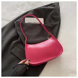 Détail du sac à main rose en forme de croissant avec texture craquelée et zip doré