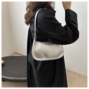 Gros plan sur le sac argenté avec texture craquelée vintage et détails métalliques