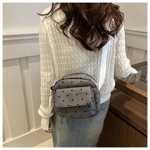 Vue arrière du mannequin portant le sac bandoulière gris à pois avec sangle blanche