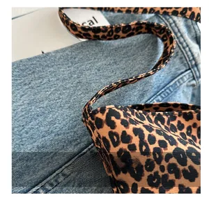 Gros plan du sac en toile léopard montrant la texture du tissu et les coutures soignées
