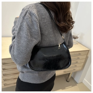 Gros plan du sac hobo noir avec texture lisse et détails de fermeture éclair dorée