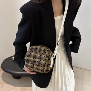Fashionable shell-shaped crossbody bag with black heart patterns and adjustable strap