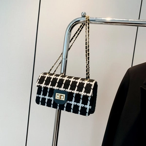 Elegante schwarz-weiße Tweed-Kettentasche mit goldenem Drehverschluss und Metallgurt