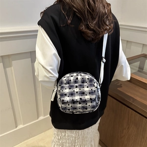 Women's blue checkered shell bag with black hearts and adjustable white shoulder strap