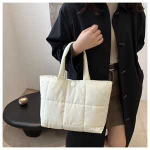 Détail du sac cabas matelassé crème avec grandes surpiqûres et fermeture à bouton
