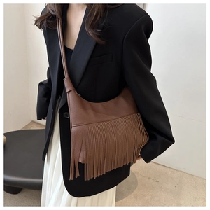 Detalle de bolso tote de cuero marrón granulado con flecos largos de estilo bohemio