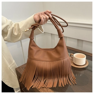 Detalle de un bolso hobo marrón de cuero sintético con flecos largos y correa con nudos
