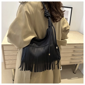 Close-up of black hobo bag with long fringes and knotted shoulder strap detail