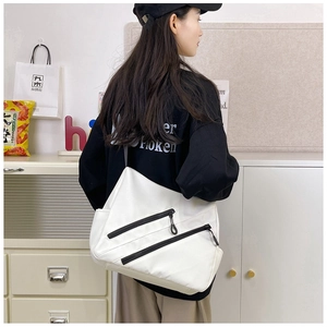 Detailed side view of large white nylon crossbody bag with dual black zipper pockets