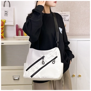 Detailed view of white nylon crossbody bag with dual diagonal zippers and side pocket