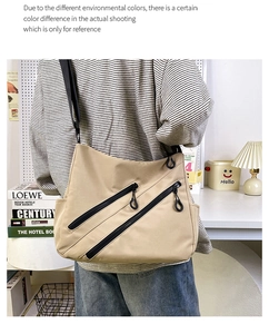 Detailed close-up of light khaki canvas tote bag with dual black decorative zippers
