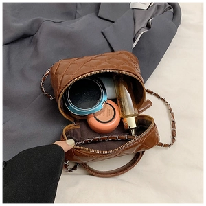 Internal view of brown quilted mini box bag showing storage space for cosmetics
