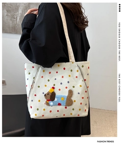 Détail du sac cabas en toile avec pois colorés et motif brodé de chien mignon
