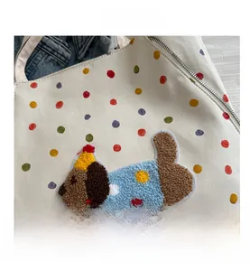 Détail du sac en toile avec pois colorés et broderie bouclée 3D en forme de chien