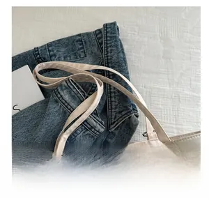 Gros plan du sac cabas en toile à pois multicolores avec des poignées robustes