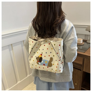 Détail du sac en toile à pois colorés et broderie de chiot doux et duveteux
