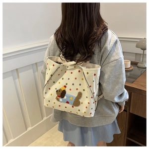 Détail du sac en toile blanche avec pois colorés et broderie de chiot en peluche en 3D