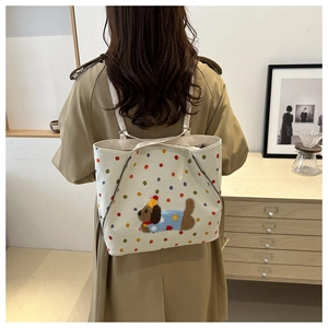 Détail du sac cabas en toile blanche avec écusson chiot en peluche 3D et pois colorés