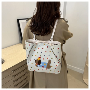 Détail du sac cabas en toile avec pois colorés et broderie d'un adorable chiot en peluche