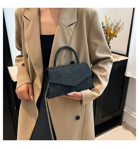 Détail du sac bandoulière à paillettes noires avec chaîne dorée et poignée ronde